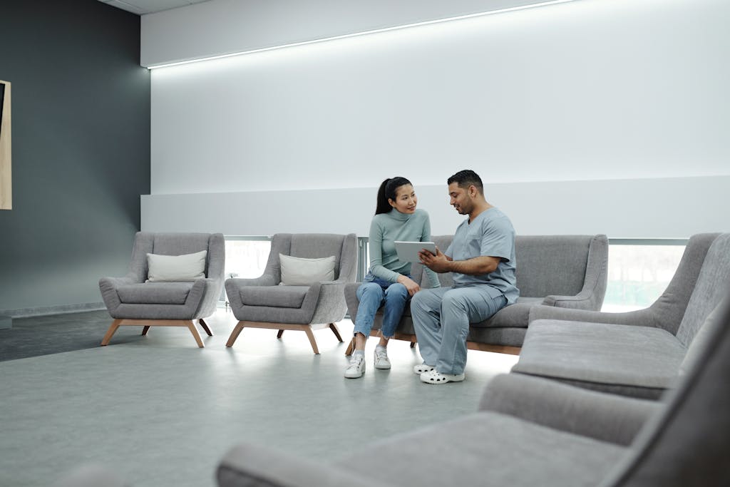 A Doctor Talking to a Patient while Holding a Tablet