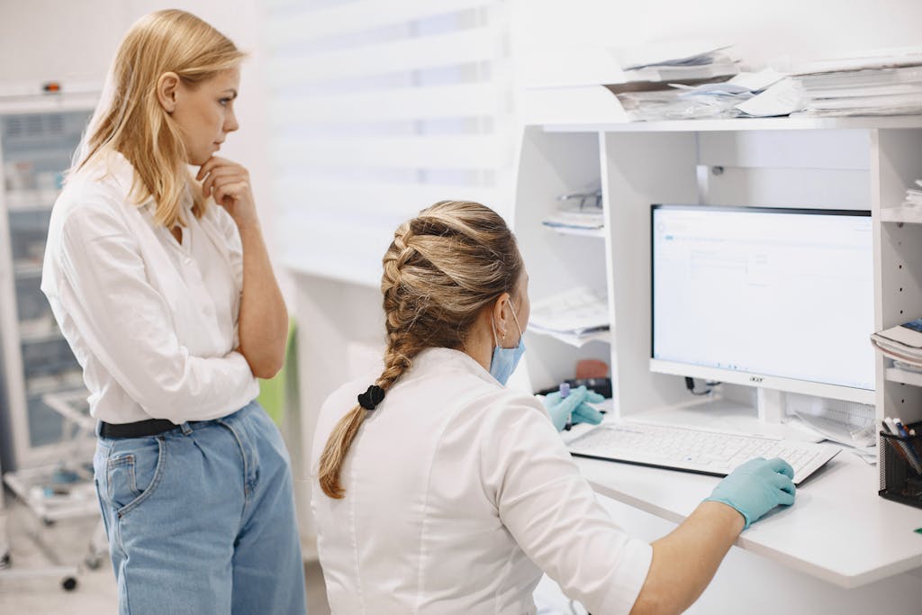 Women Looking at Computer Screen Inside Medical Clinic