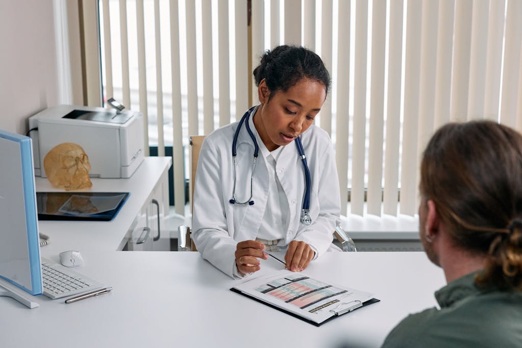 A doctor consulting with a patient in an office, discussing a medical chart.